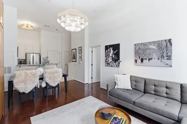 a living room with furniture a dining table and a chandelier