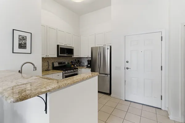 a kitchen with stainless steel appliances granite countertop a refrigerator and a stove top oven