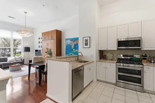 a kitchen with stainless steel appliances a stove refrigerator sink and microwave