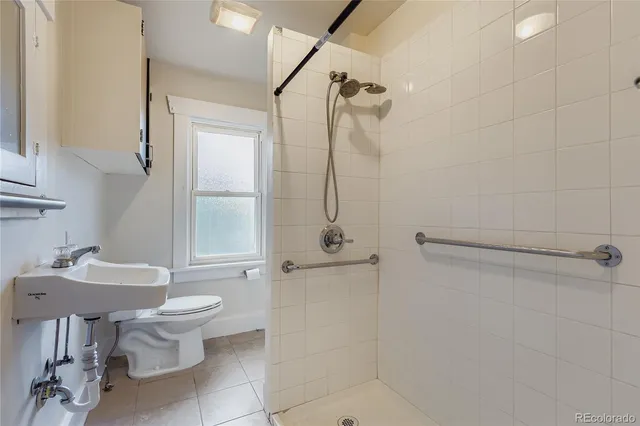 a bathroom with a granite countertop sink a toilet and shower