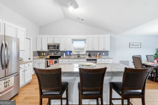 a kitchen with stainless steel appliances a white table and chairs