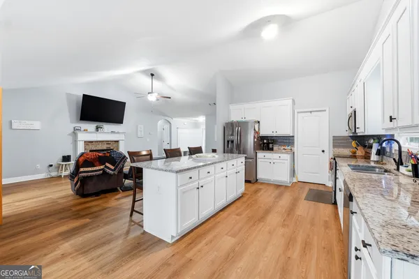 a kitchen that has a lot of cabinets and a wooden floor