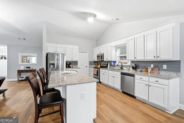 a kitchen with refrigerator cabinets and chairs