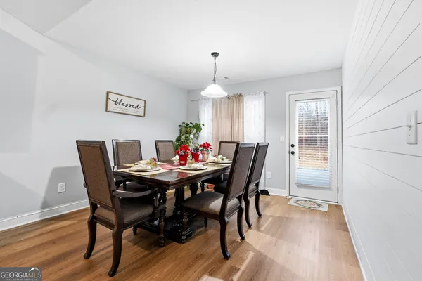 a dining room with furniture a chandelier and wooden floor
