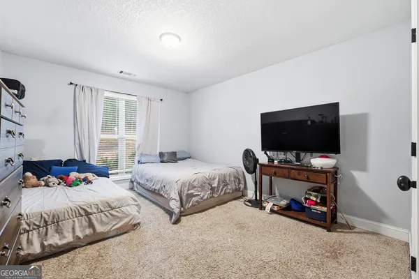 a bedroom with two beds and a flat screen tv