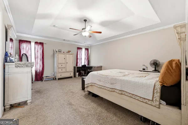 a spacious bedroom with a bed and a chandelier