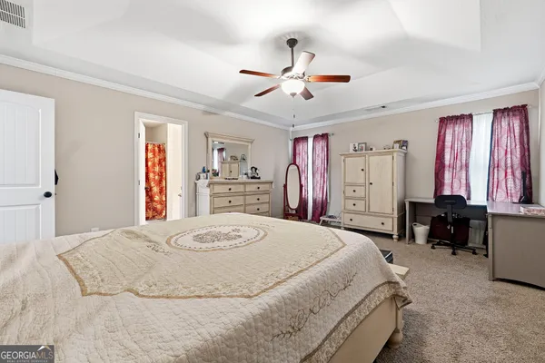 a bedroom with a bed and dresser with chair