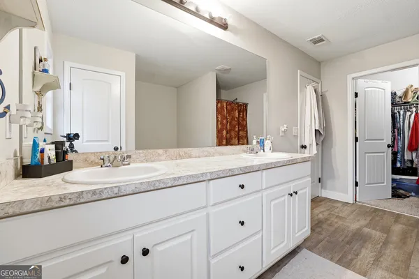 a bathroom with double sink and a mirror