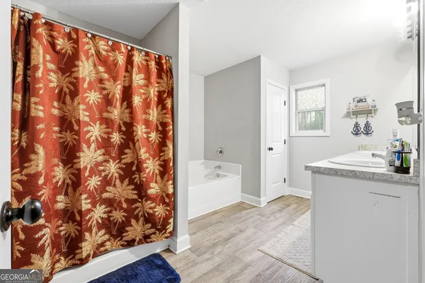 a bathroom with a granite countertop sink and a bathtub