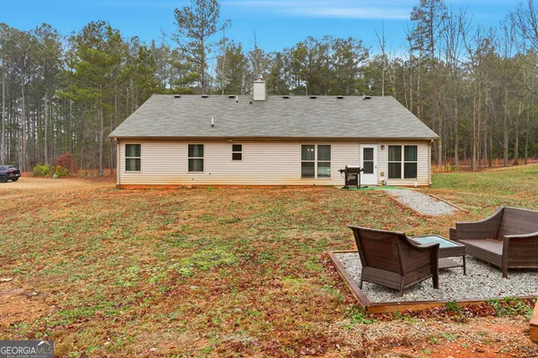 a backyard of a house with table and chairs