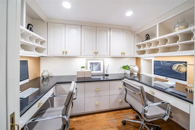 a spacious bedroom with a bed a dresser and wooden floor