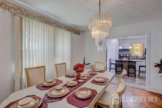 a dining room with furniture a chandelier and wooden floor