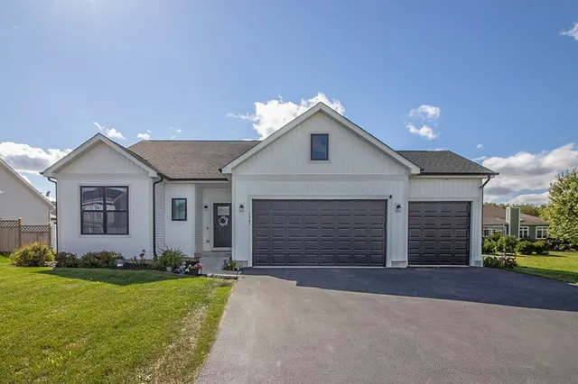 a front view of a house with a yard and garage