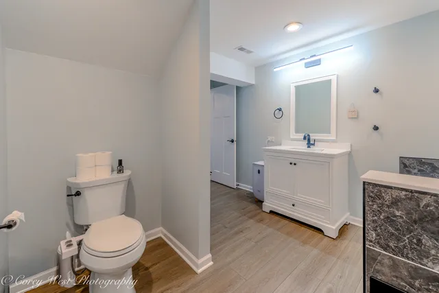 a bathroom with a toilet sink and mirror