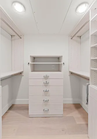 a spacious bathroom with a granite countertop sink a toilet a mirror and shower