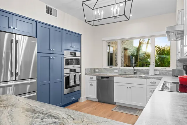 a kitchen with stainless steel appliances granite countertop a refrigerator and a sink