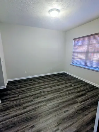 a view of a room with wooden floor and window