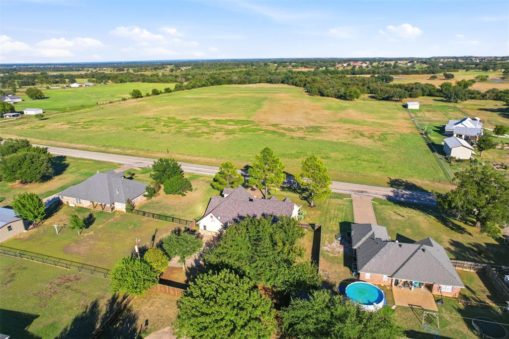 207 Dennis Road Lipan, TX 76462 - Photo 35 of 40 Expansive property featuring a large green field, multiple residential structures, and mature trees