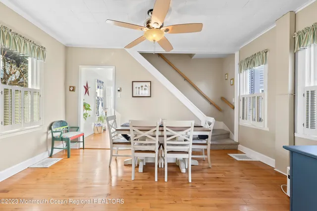 a dining room with wooden floor a chandelier a glass table and chairs