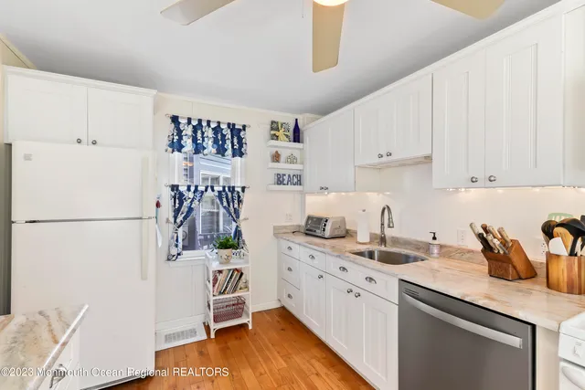 a kitchen with a sink a refrigerator and cabinets