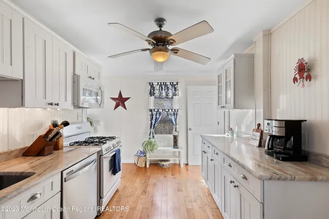 a kitchen with white cabinets and appliances