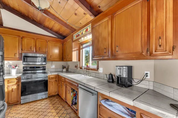 a kitchen with stainless steel appliances granite countertop a refrigerator a stove and a sink