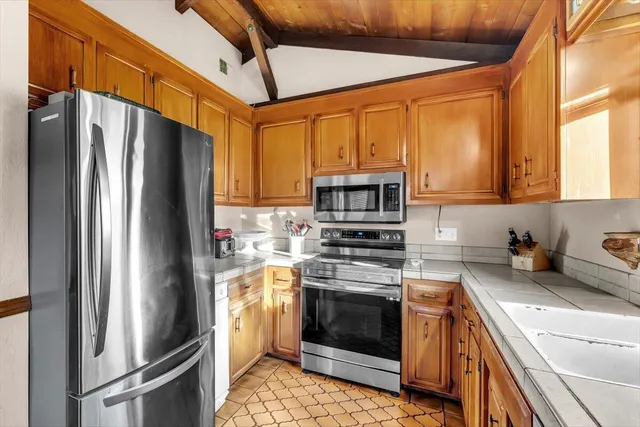 a kitchen with stainless steel appliances granite countertop a sink a stove cabinets and a counter top space