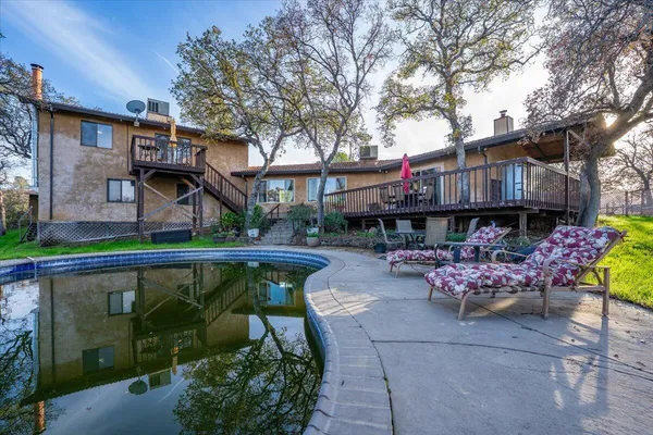 a front view of a house with garden and sitting area