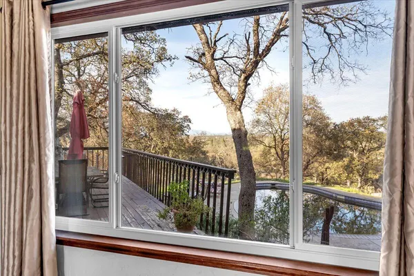 a view of a room with a large window and wooden fence