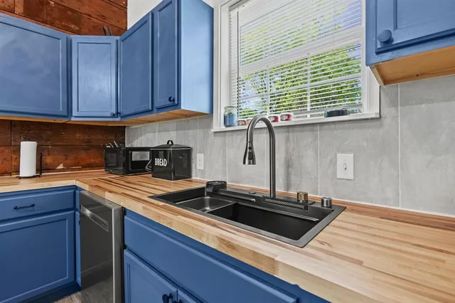 a kitchen with granite countertop a sink stainless steel appliances and cabinets