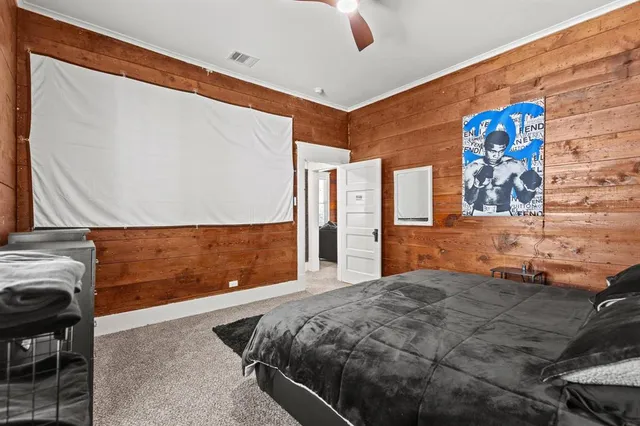 a bedroom with a bed and painting on the wall