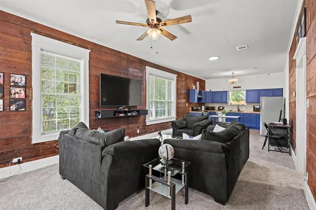 a living room with furniture ceiling fan and a window