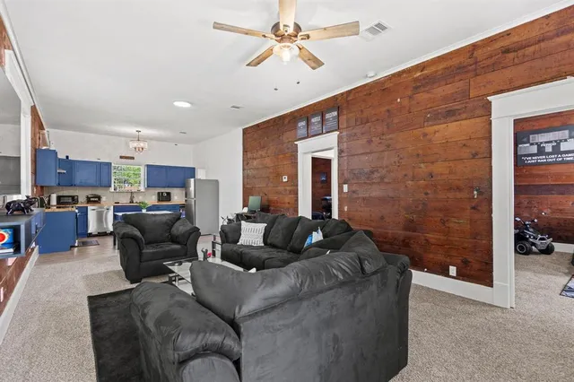 a living room with furniture kitchen view and a chandelier