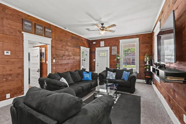 a living room with furniture ceiling fan and a rug