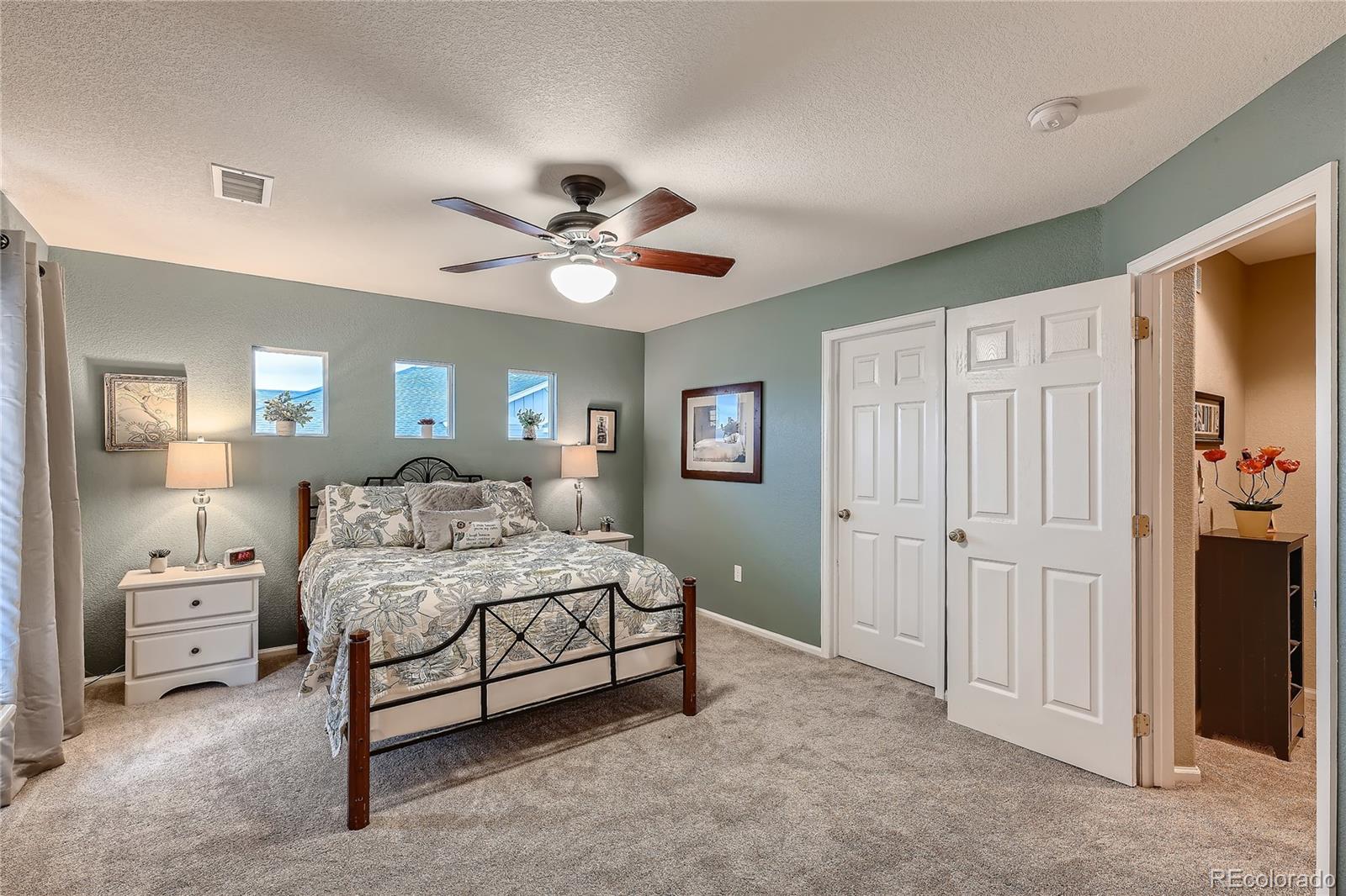 166 Whitehaven Circle Highlands Ranch, CO 80129 - Photo 16 of 28 a spacious bedroom with a bed a table and chair