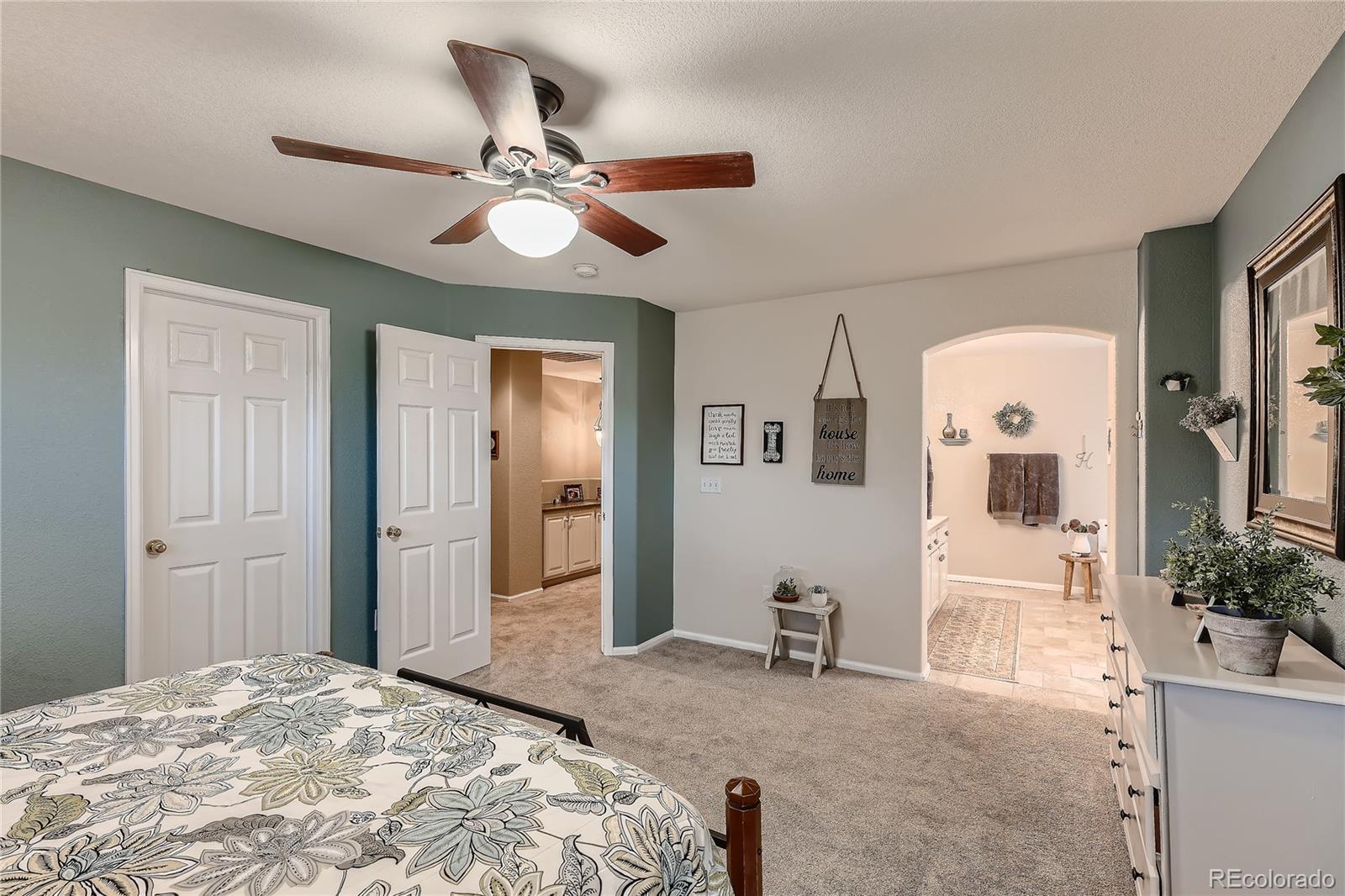 166 Whitehaven Circle Highlands Ranch, CO 80129 - Photo 17 of 28 a bedroom with a bed and a chandelier