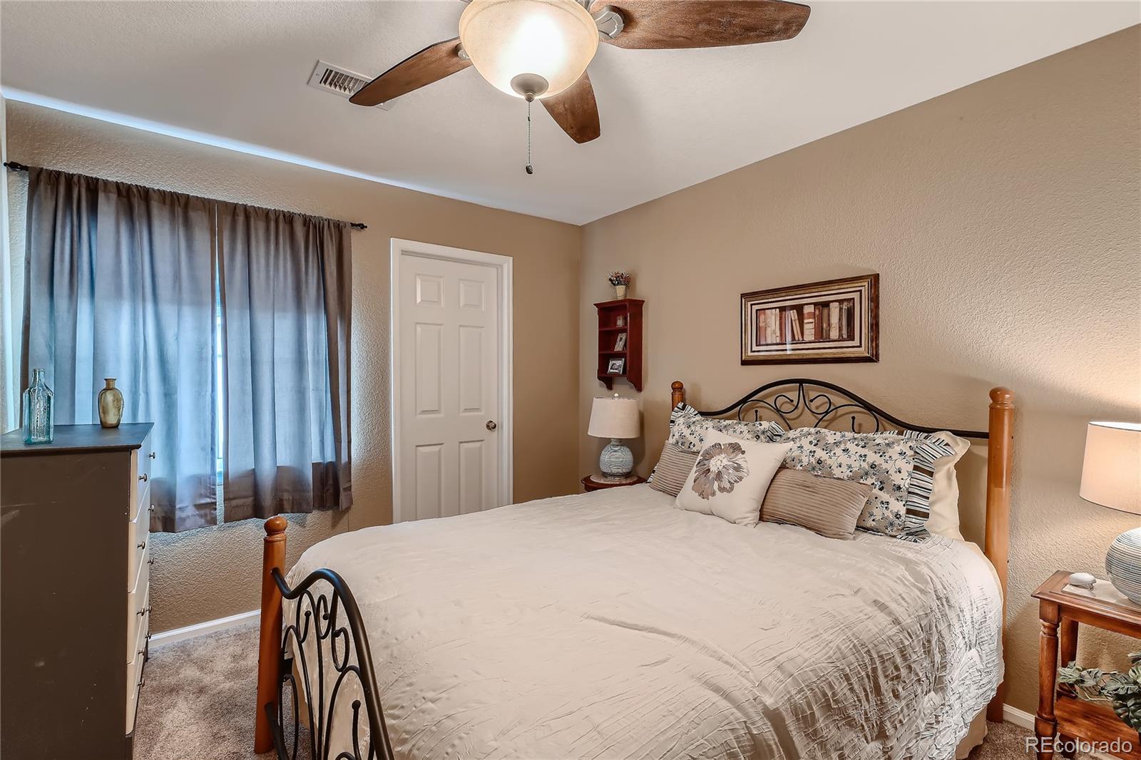 166 Whitehaven Circle Highlands Ranch, CO 80129 - Photo 19 of 28 a bedroom with a bed and a chandelier