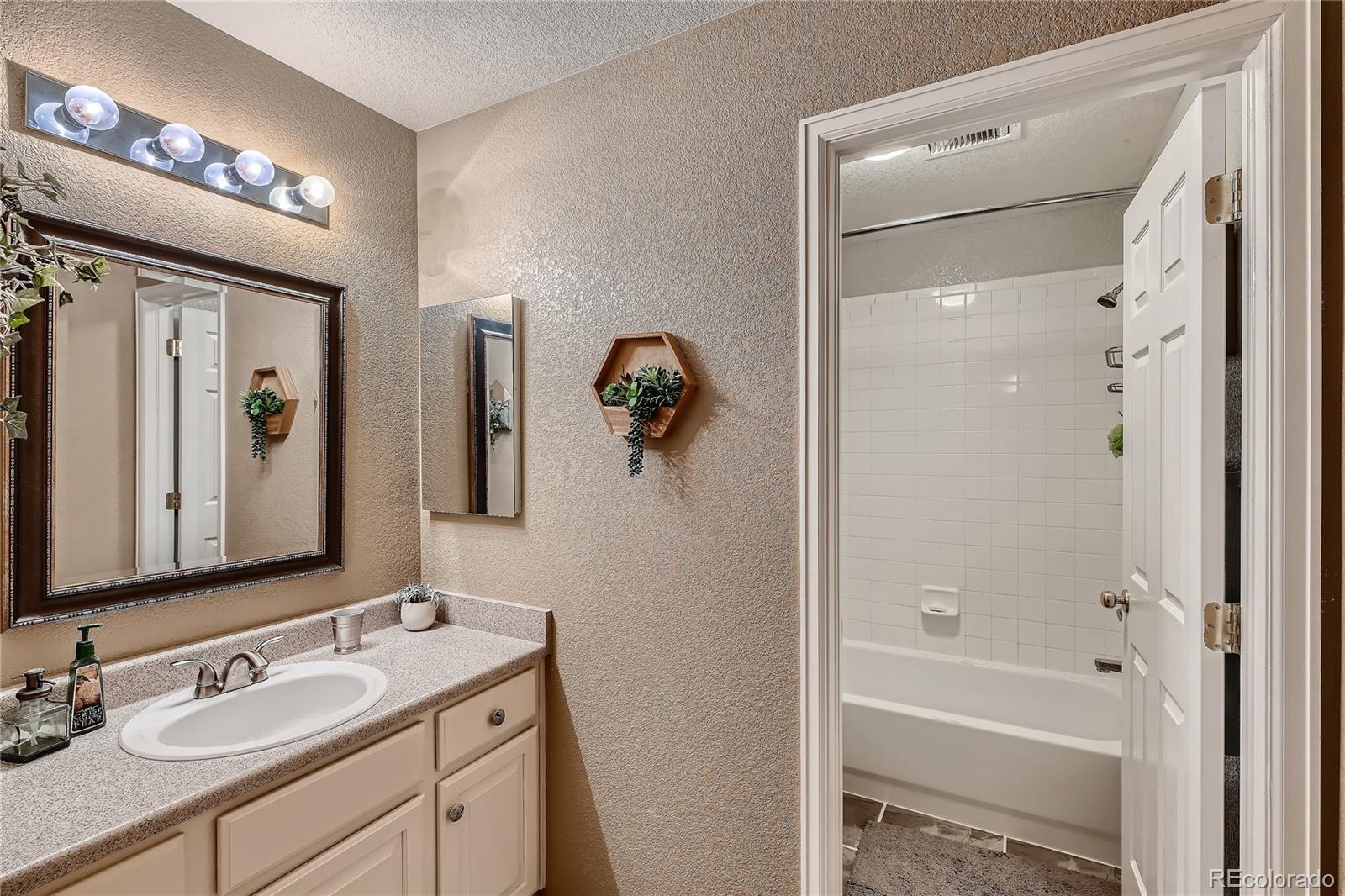 166 Whitehaven Circle Highlands Ranch, CO 80129 - Photo 20 of 28 a bathroom with a granite countertop sink vanity mirror and shower