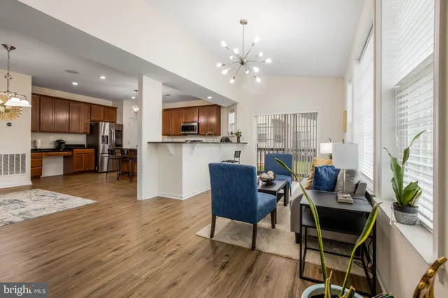 a living room with furniture a flat screen tv and kitchen view