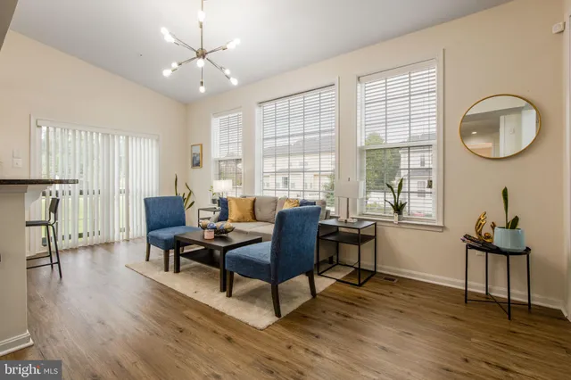 a living room with furniture a window and wooden floor