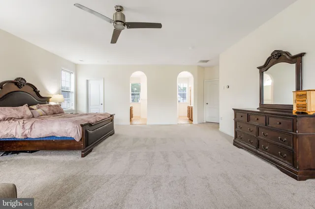 a bedroom with a bed and dresser with mirror