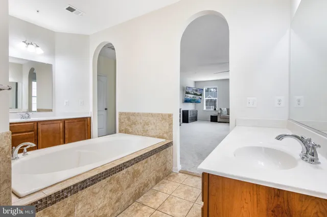 a en suite bathroom with a granite countertop sink and a mirror