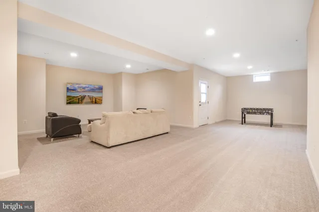 a spacious bedroom with a bed a couch and a dresser with rug