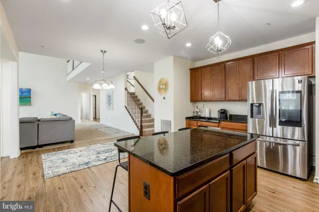 a kitchen with stainless steel appliances granite countertop a sink refrigerator and cabinets