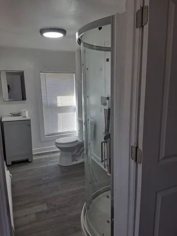 a bathroom with a granite countertop toilet a sink and a mirror