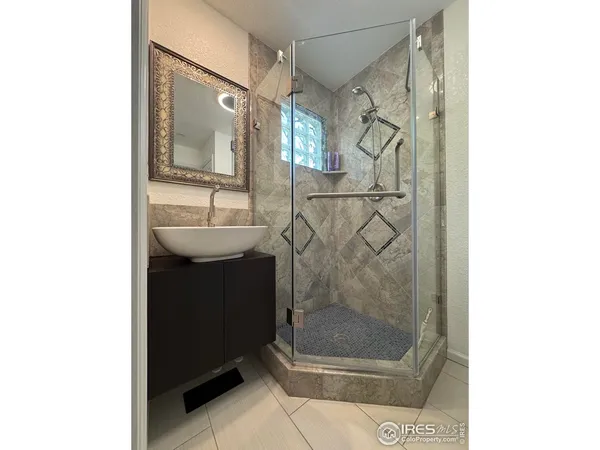 a spacious bedroom with a bed a mirror and a large window