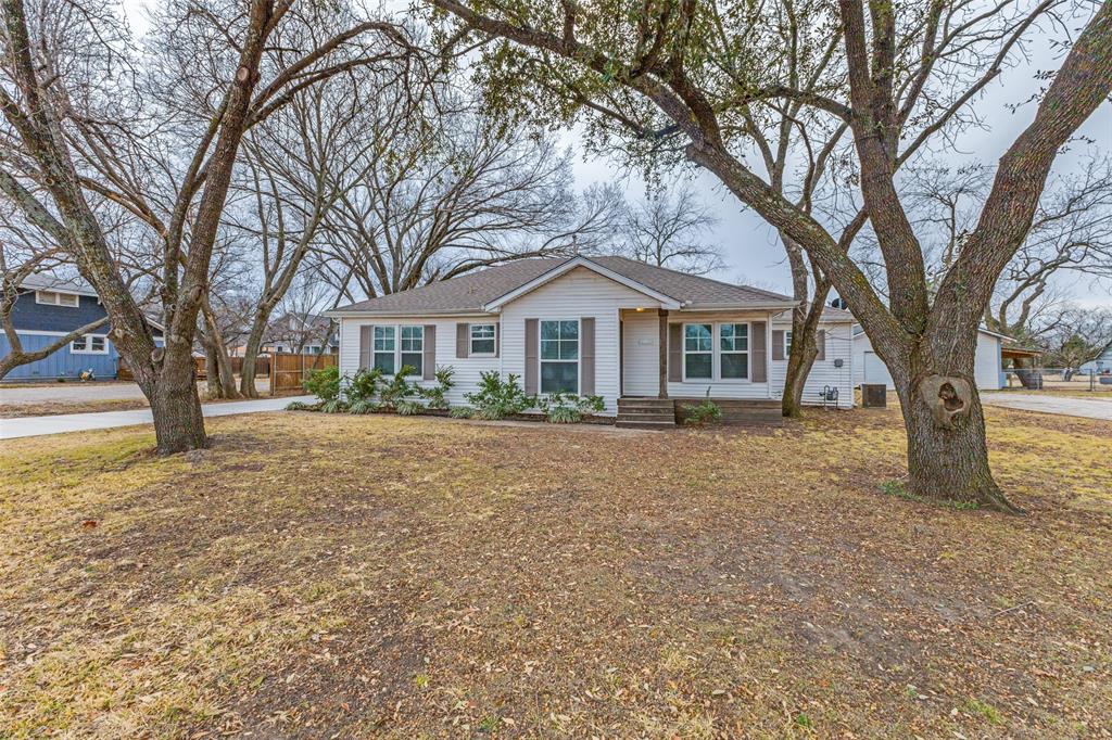 a front view of a house with a yard and trees