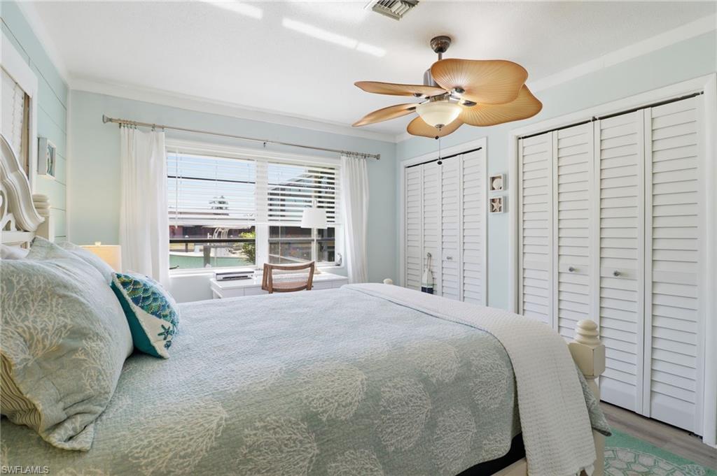 2211 Bayview Road Punta Gorda, FL 33950 - Photo 32 of 37 Bedroom with two closets, crown molding, ceiling fan, and wood finished floors