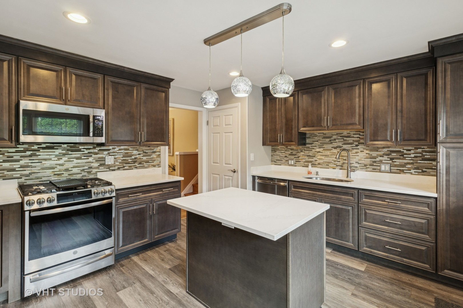 53 North Main Street Glen Ellyn, IL 60137 - Photo 3 of 30 a kitchen with stainless steel appliances kitchen island granite countertop a sink stove and microwave