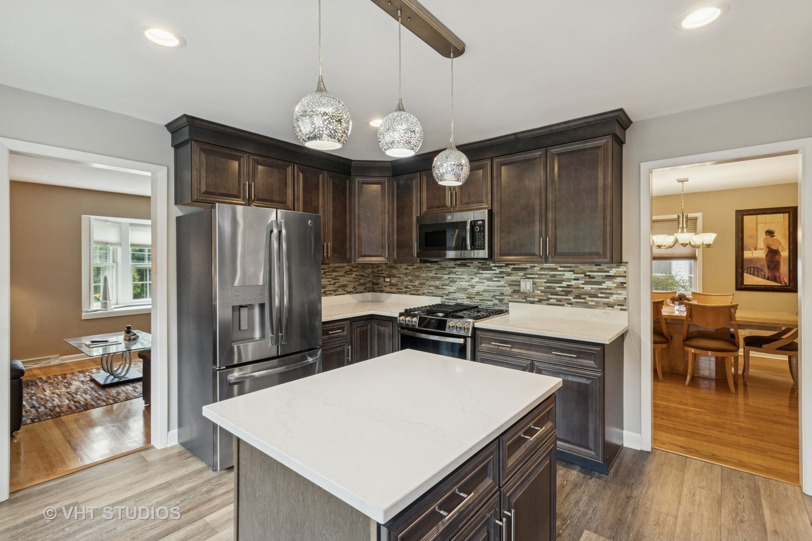 53 North Main Street Glen Ellyn, IL 60137 - Photo 5 of 30 a kitchen with a refrigerator a stove a sink and a dining table with wooden floor